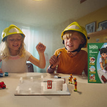 Load image into Gallery viewer, Two children playing with a toy building set and figurines, with a 'Buildits' toy box in the background.