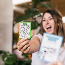 Load image into Gallery viewer, Person holding two cards from the game Muffin Time with illustrations and text, one labeled 'NOPE!' in a casual setting.