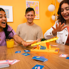 Load image into Gallery viewer, Three people playing a board game with a yellow 'Tilt and Shout' toy at a table.