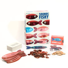Load image into Gallery viewer, Sounds Fishy game set with fish-shaped cards and coins on a white background
