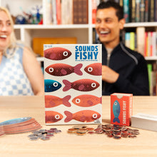 Load image into Gallery viewer, Board game &#39;Sounds Fishy&#39; with players in the background
