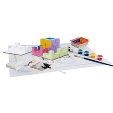 Load image into Gallery viewer, Colorful building block set on a white surface with tools and paint supplies.
