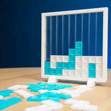 Load image into Gallery viewer, Tetris-like puzzle game with blue and white blocks on a wooden surface against a dark blue background
