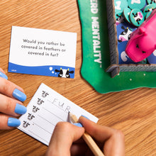 Load image into Gallery viewer, Person playing a card game with a question card and a scoring device on a wooden table.
