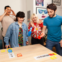 Load image into Gallery viewer, Four friends playing chicken vs hotdog together at a table with colorful cards.
