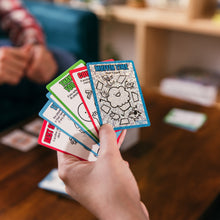 Load image into Gallery viewer, Hand holding Muffin Time cards with colorful designs in a casual setting
