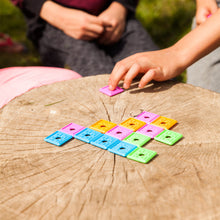 Load image into Gallery viewer, Children playing with colorful square tiles on a wooden surface outdoors.
