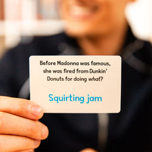 Load image into Gallery viewer, Person holding a card with a humorous question about Madonna and Dunkin&#39; Donuts from the game Sounds Fishy.
