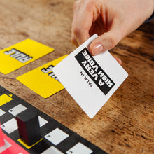 Load image into Gallery viewer, Hand holding a card with text on a wooden surface with other cards.
